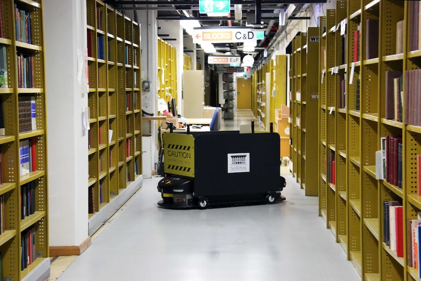 A robot helps deliver a trolley of books.