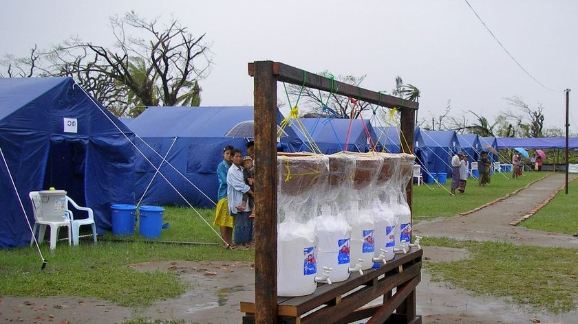 Drinking water dispensers are set up near a row of tent shelters in Burma