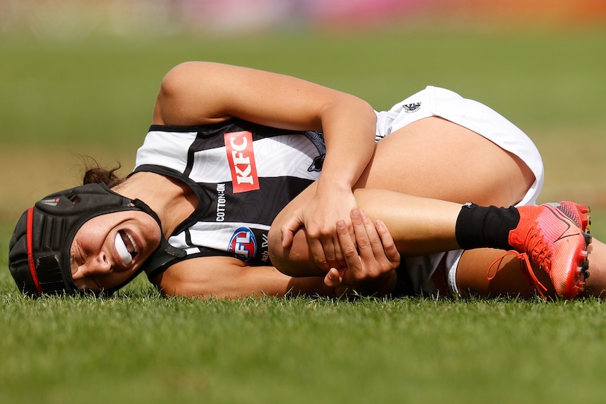 Collinngwood AFLW player Britt Bonnici lays prone after injuring her ACL in 2022