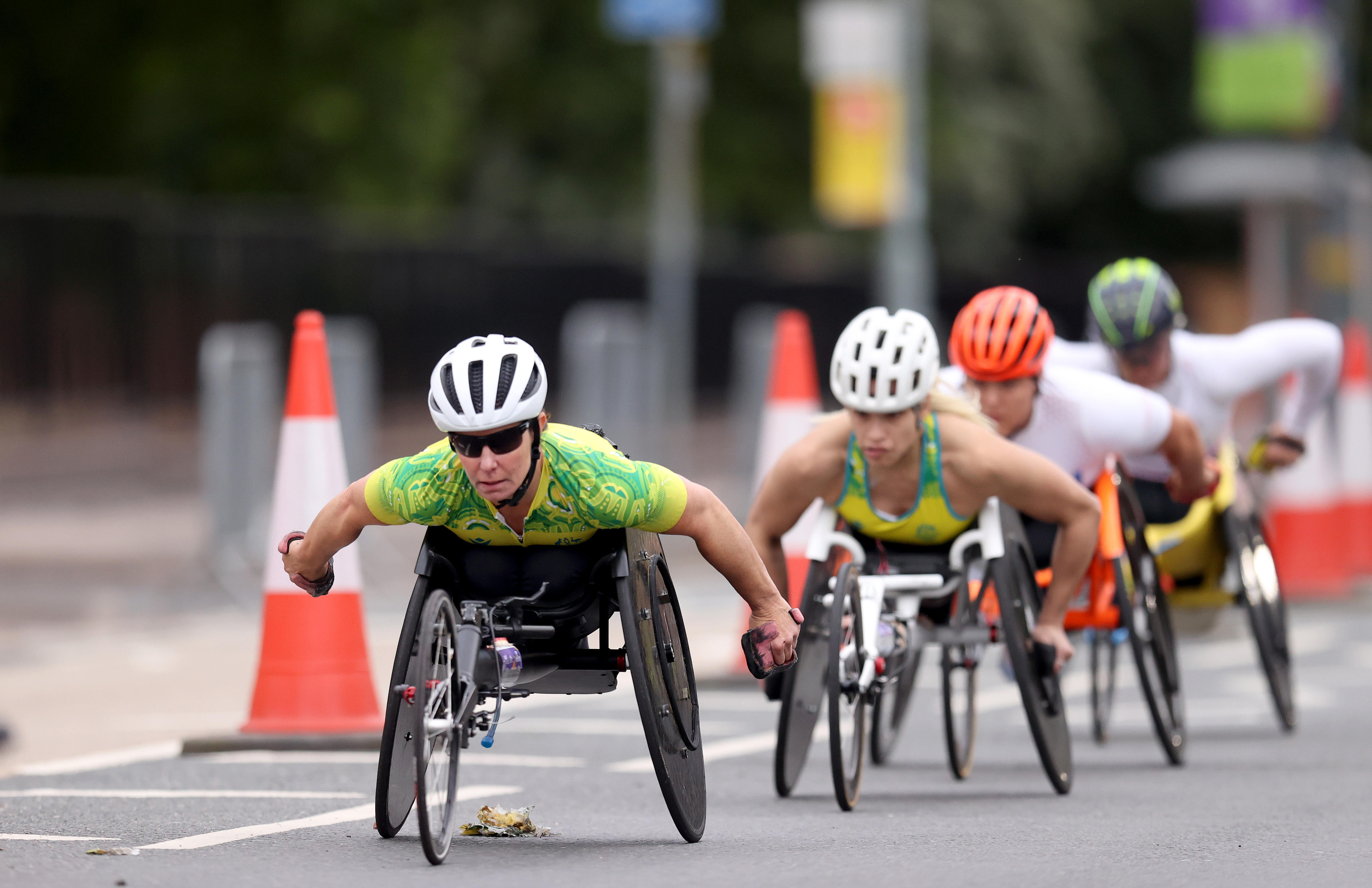 Women wheelchair racers compete in an event on the road