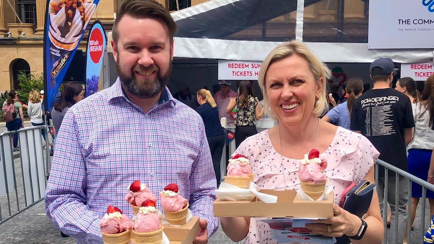 Two people holding ice-cream cones.