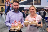 Two people holding ice-cream cones.