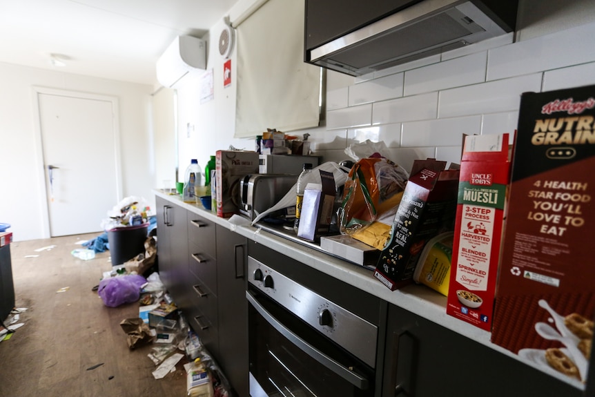 Warwick Allen's filthy kitchen bench top filled with discarded food packets and cereal boxes.