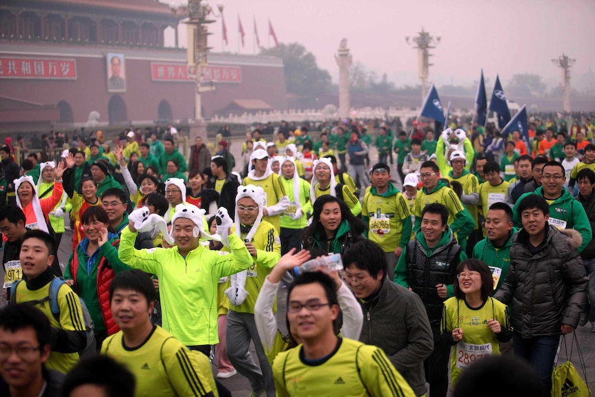 Participants run on a hazy day for the Beijing International Marathon
