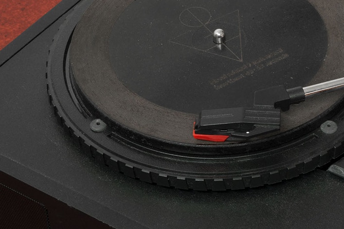 A plan black record sits on a plain black record player.