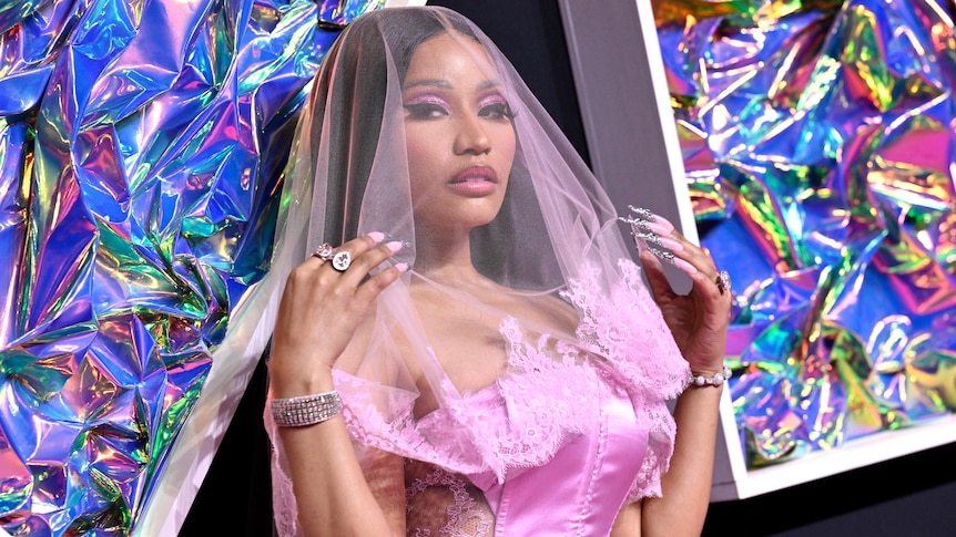 A woman in pink dress and a veil.