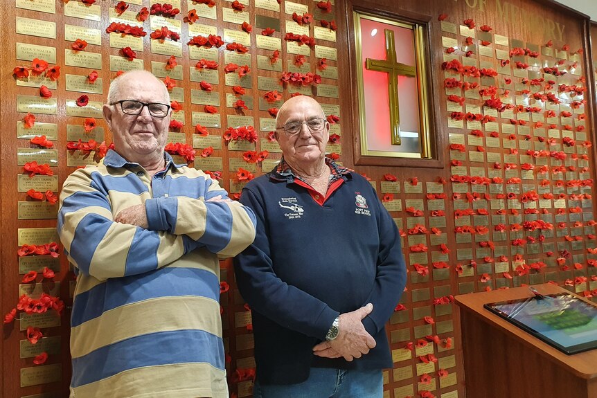 Haydn Madigan and Jeff Kenyon stand in front of a war memorial in the Port Pirie RSL. 