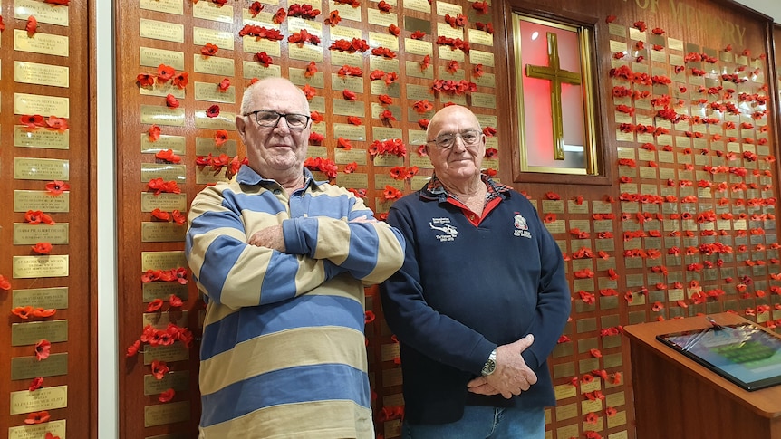 Haydn Madigan and Jeff Kenyon stand in front of a war memorial in the Port Pirie RSL. 