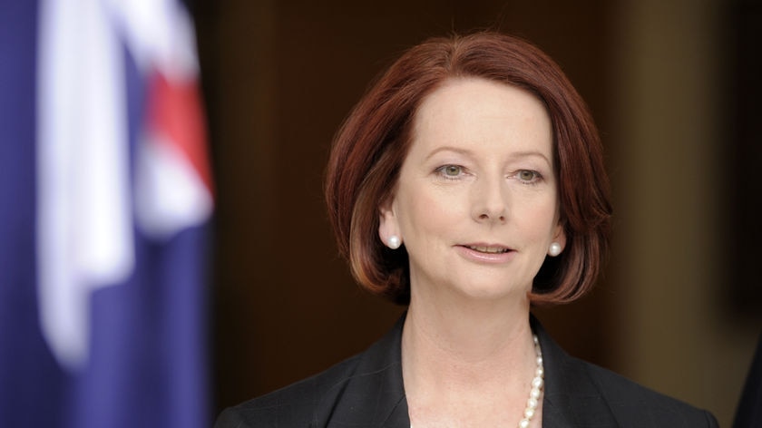 Prime Minister Julia Gillard speaking with Australian flag beside her (AAP: Mark Graham)