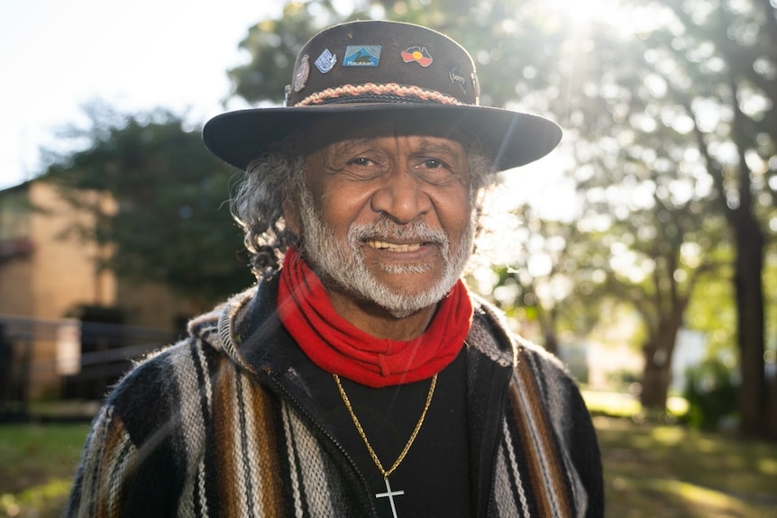 Pastor Raymond Minniecon wearing a wide-brimmed hat and smiling at the camera.