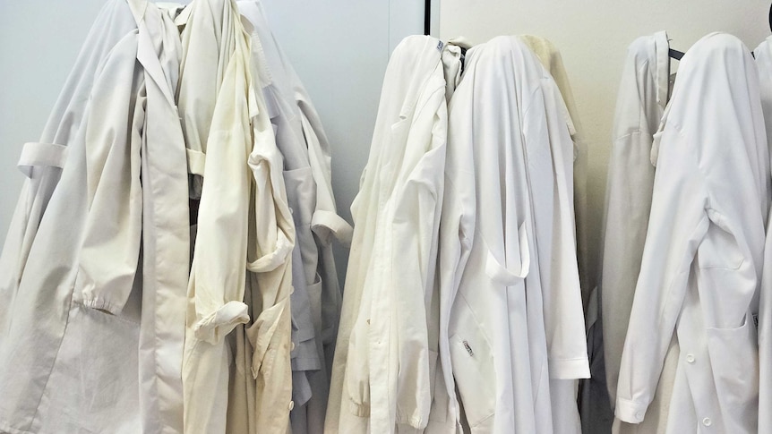 Lab coats of scientists hanging on hooks