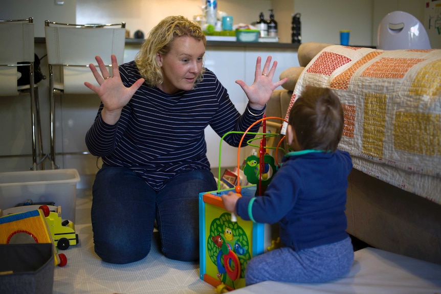 Perth foster carer Elisha Rose plays with toys on the floor with her foster child