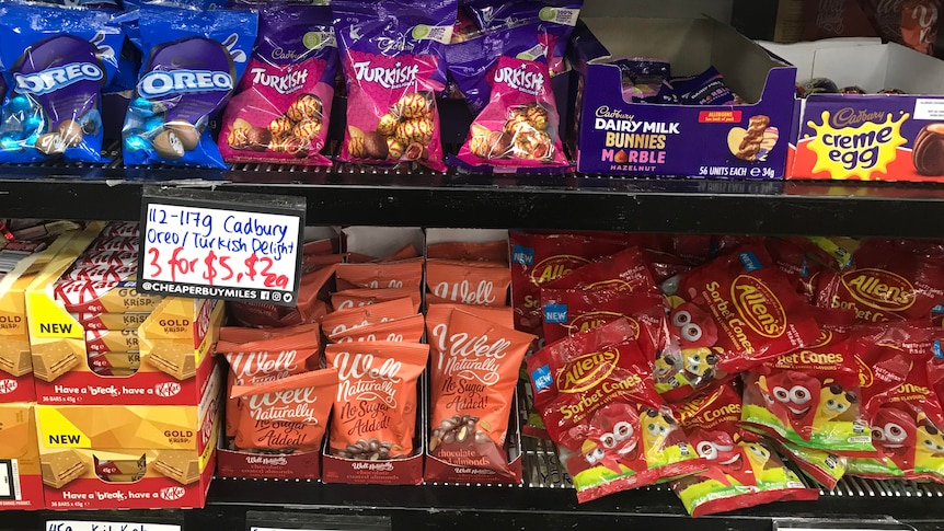 Packets of Easter eggs on shelves inside a shop.