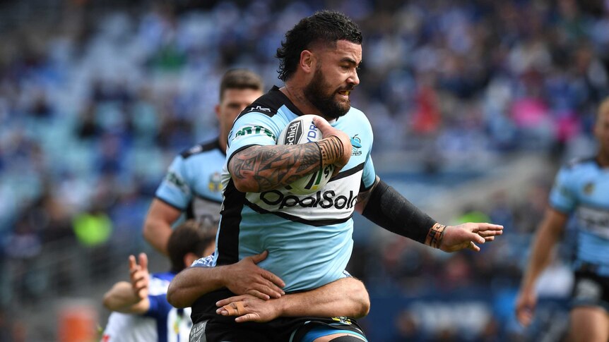 Andrew Fifita carrying the ball as he is tackled by Josh Morris.