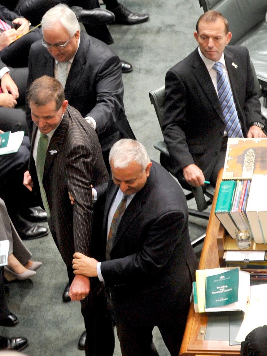 Tony Abbott watches Pater Slipper being taken to the Speaker's chair.