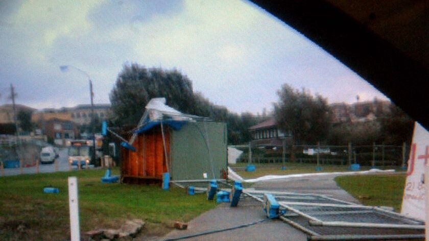 A shed and fencing at Clovelly beach lies on their side after being blown over during high winds