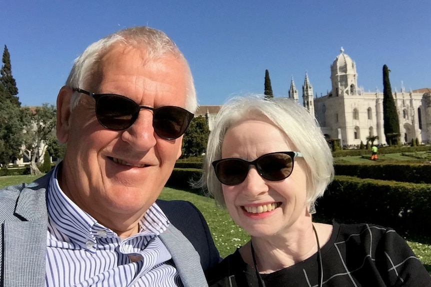Ian and Helen Anderson pose for a selfie in front of a castle.