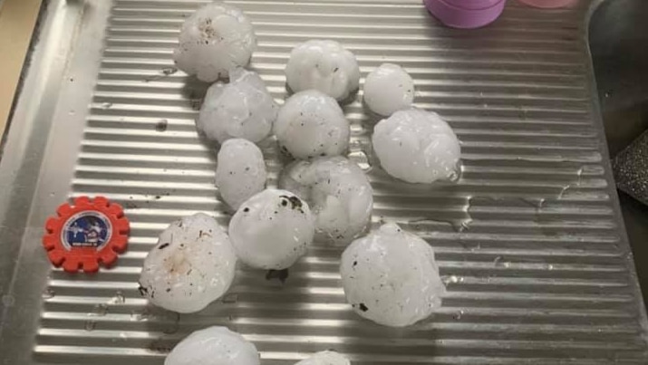 A handful of large hailstones sit on a kitchen bench.