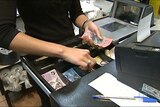 Shop assistant takes money from cash register.