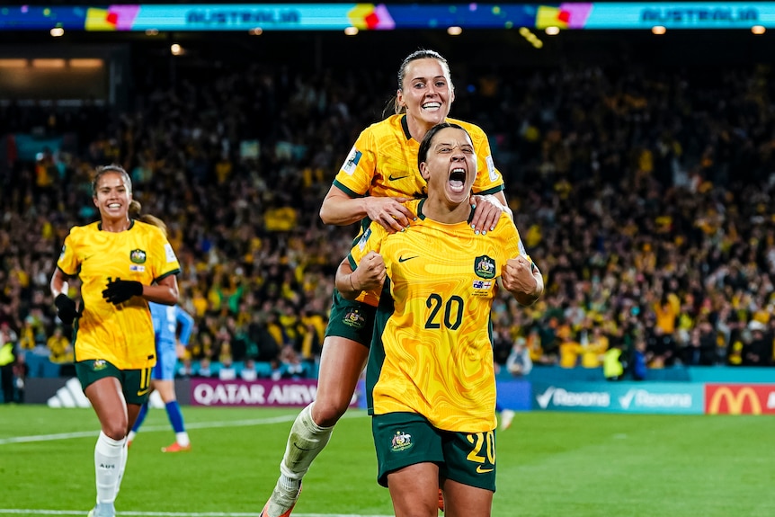 Two female footballers celebrating after a game win 