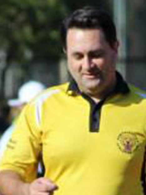 Bradley Robert Edwards wearing a yellow shirt walking on grass towards the camera.