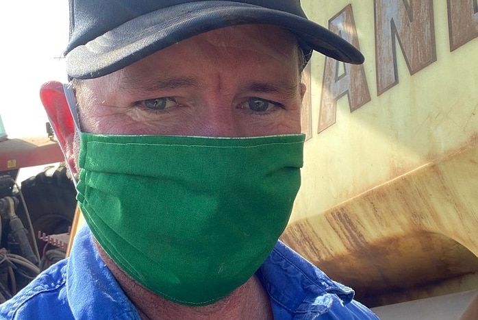Grain Producers Australia Chairman Andrew Wiedemann standing next to a truck wearing a face mask.