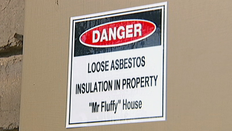 Sign on fuse box identifying a house as a Mr Fluffy loose-fill asbestos home.