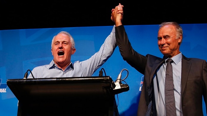 Prime Minister Malcolm Turnbull and John Alexander raise their arms celebrating Alexander's re-election