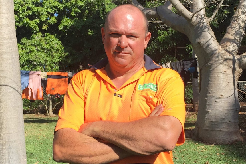 Cameron White standing in a sunny yard, surrounded by trees.