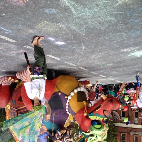 Performers wave next to a giant dragon float