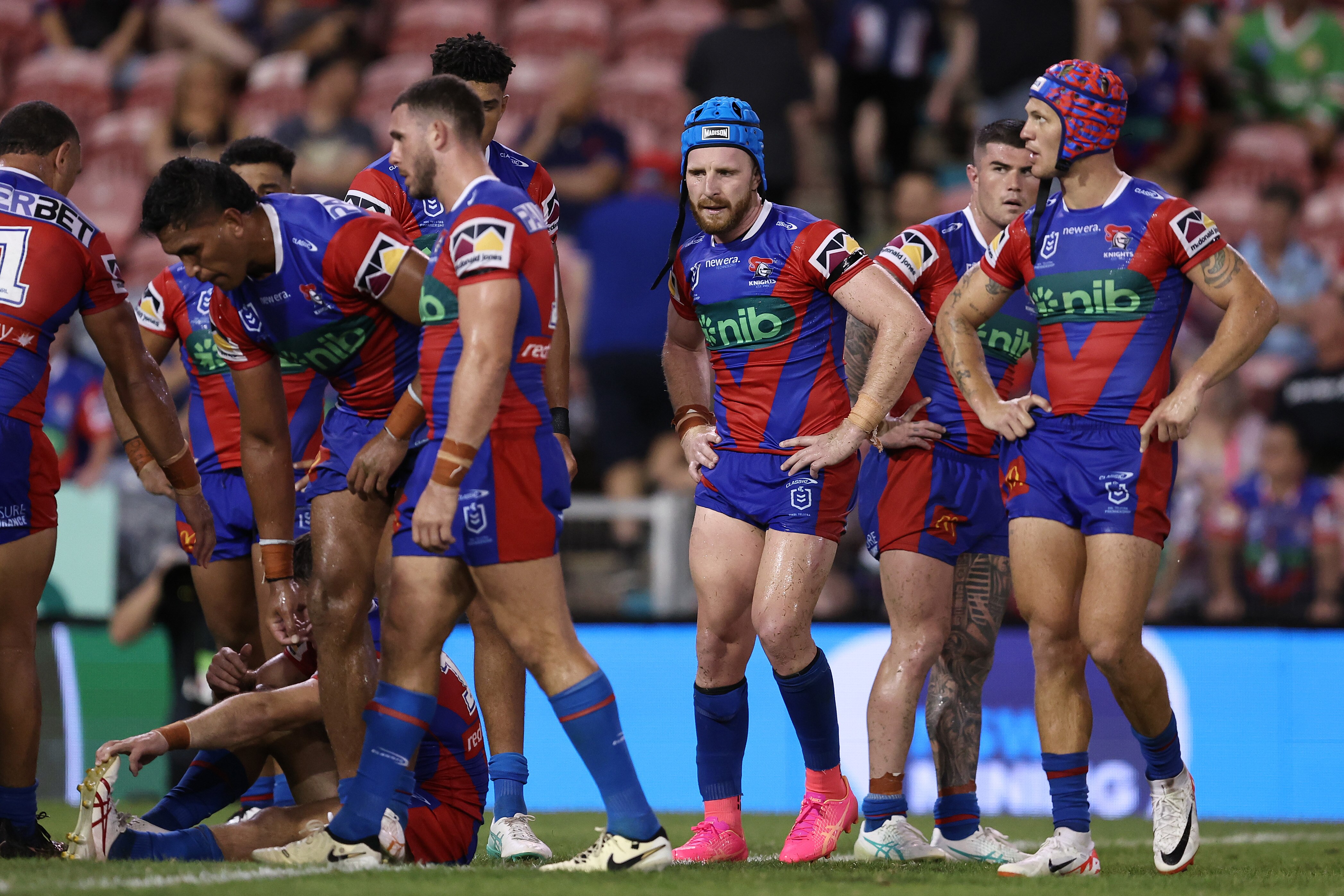A group of rugby league players look despondent after losing a match