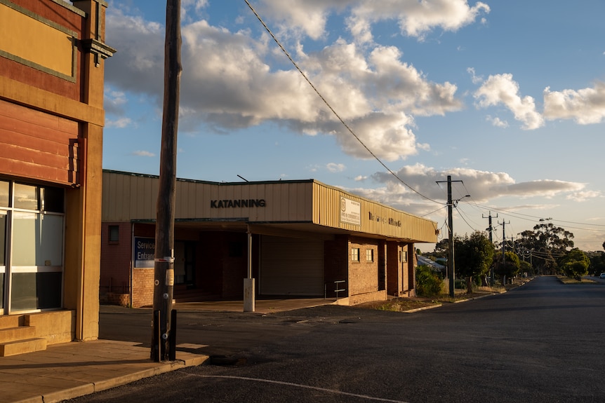 A wide empty street with an old brick building