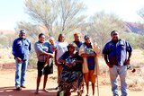 Docker Rangers and Mutitjulu women stand in front of Uluru