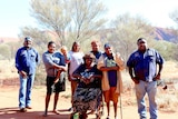 Docker Rangers and Mutitjulu women stand in front of Uluru