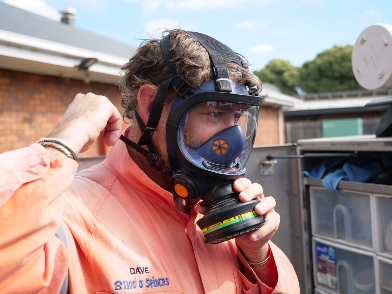 A man in a gas mask and hi-vis