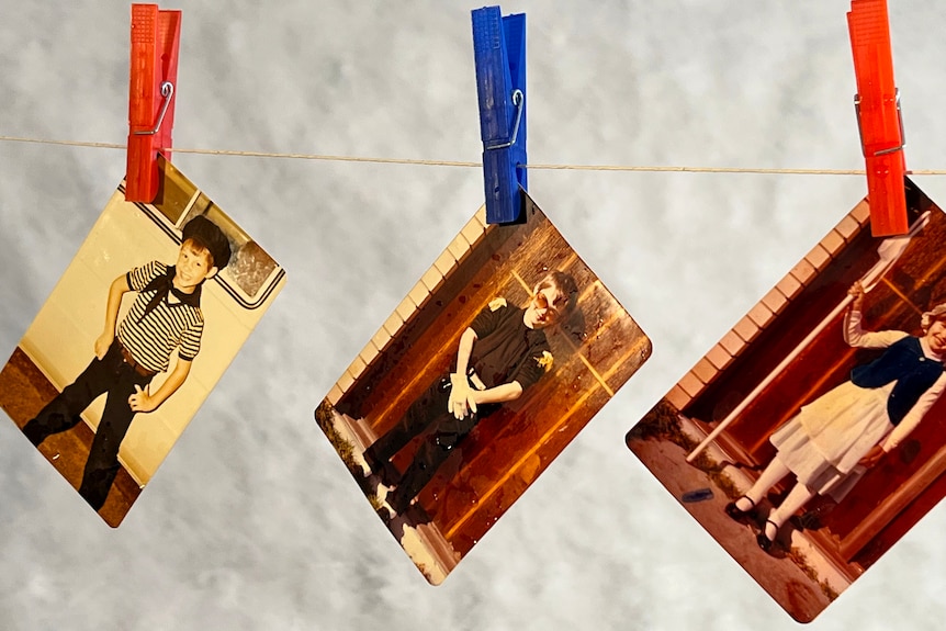 Three printed photos, hanging on a line held by pegs, drying out after being damaged by flood waters.