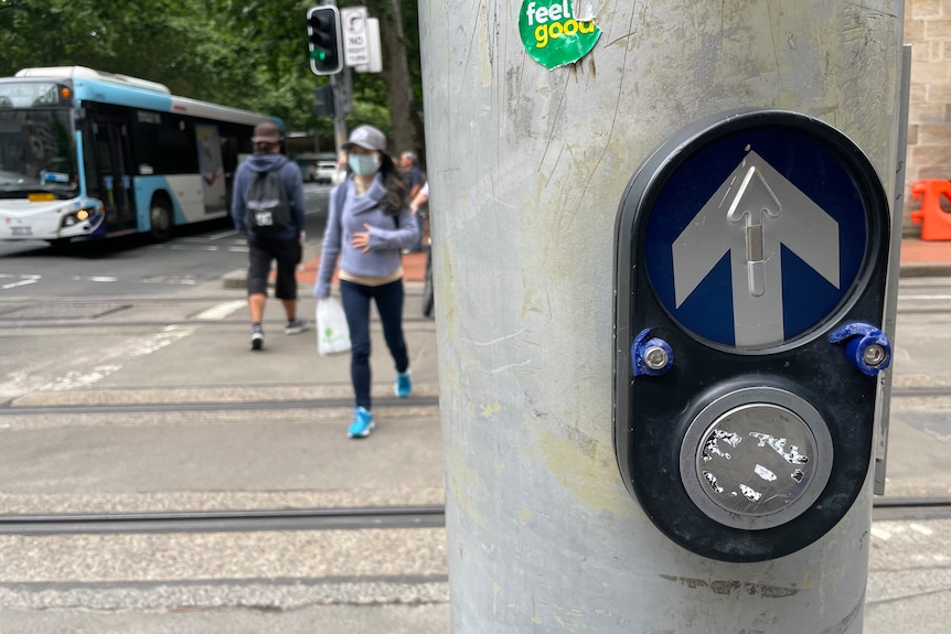 A pedestrian crossing button cover that has been vandalised