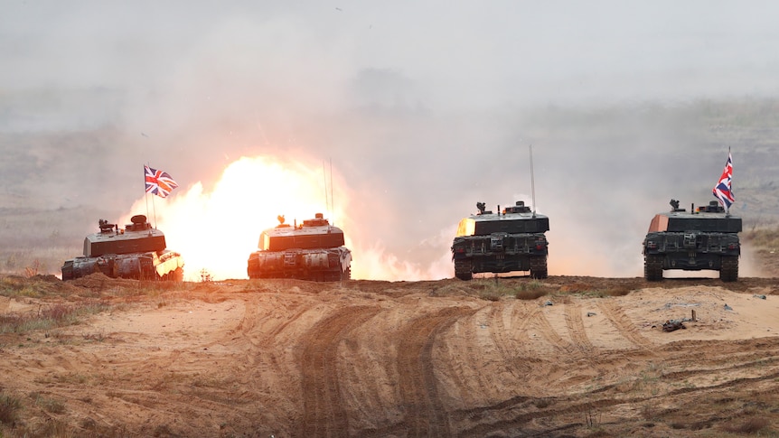 Four British Army Challenger 2 tanks fire during exercise.