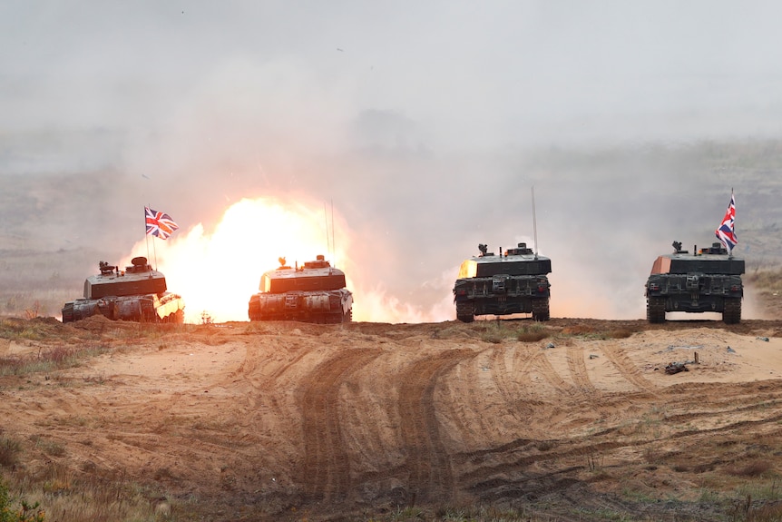 Four British Army Challenger 2 tanks fire during exercise.