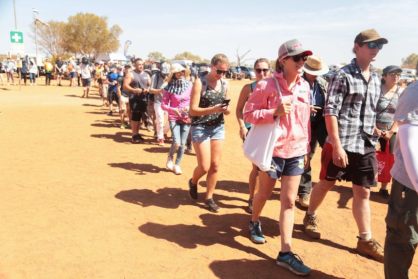 Crowds of happy people walk together as the Uluru climb re-opens.