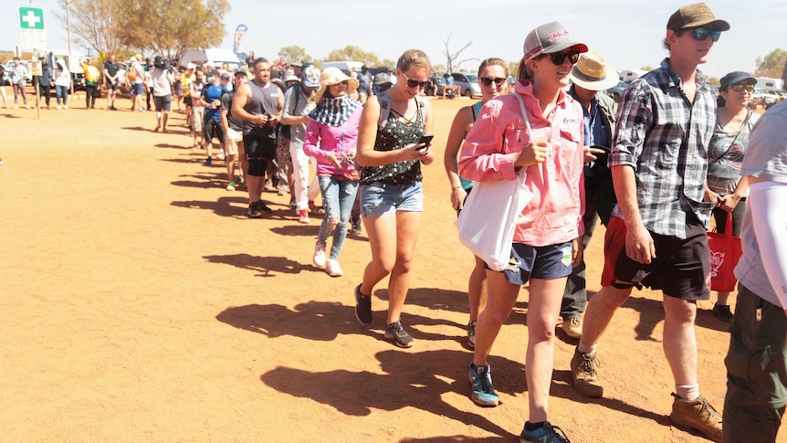 Crowds of happy people walk together as the Uluru climb re-opens.