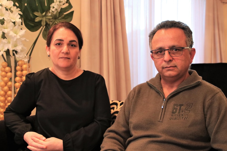 A man and a woman sitting on a couch together.