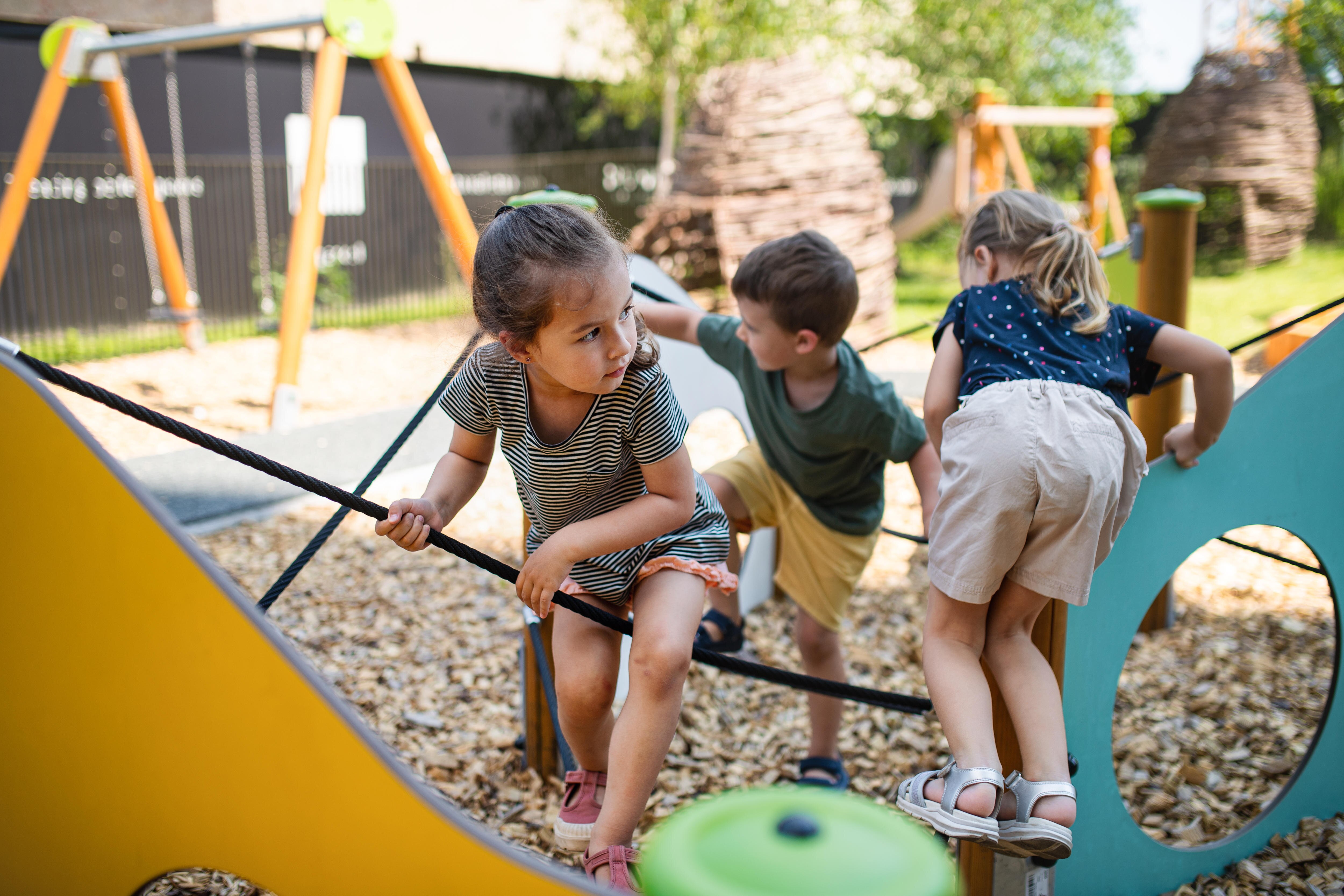 young girl plays on the playground with friends