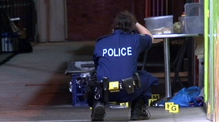 A police officer gathers evidence at a Sydney crime scene.