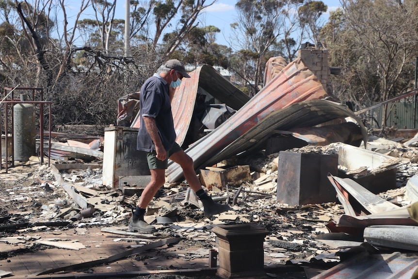 A man walks through fire damage 