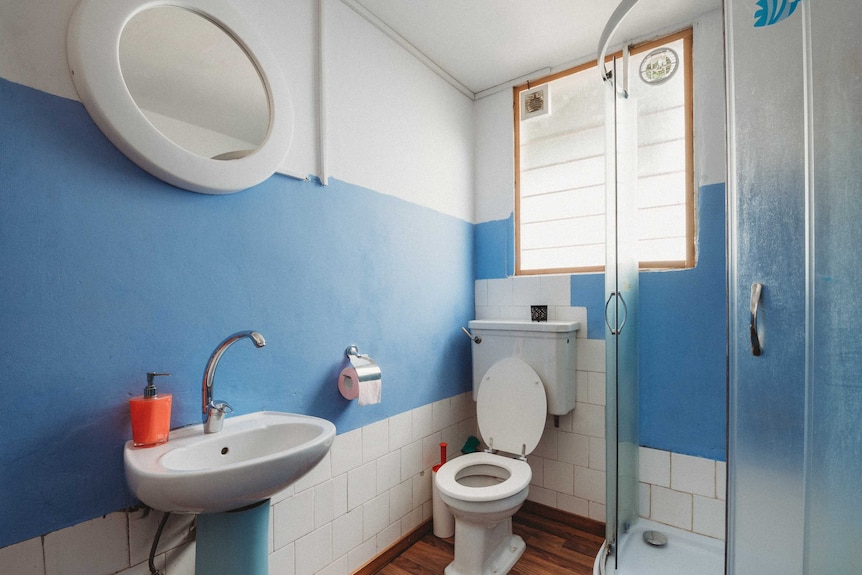 Old fashioned bathroom with sink, toilet and shower.