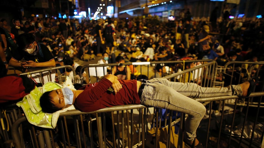 A pro-democracy protester sleeps over a barricade at the Mong Kok shopping district of Hong Kong October 20, 2014.