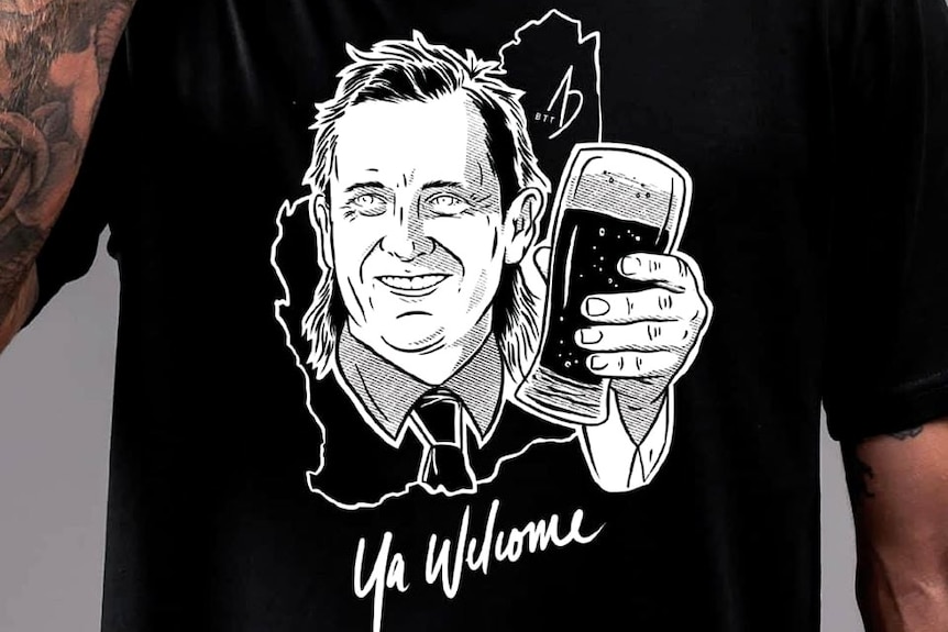 A man wearing a black t-shirt with a cartoon image of Mark McGowan drinking a beer and the words 'ya welcome' written on it.