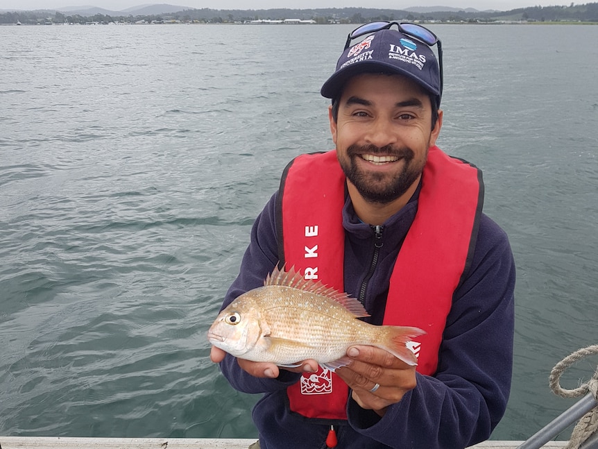 man holding small fish