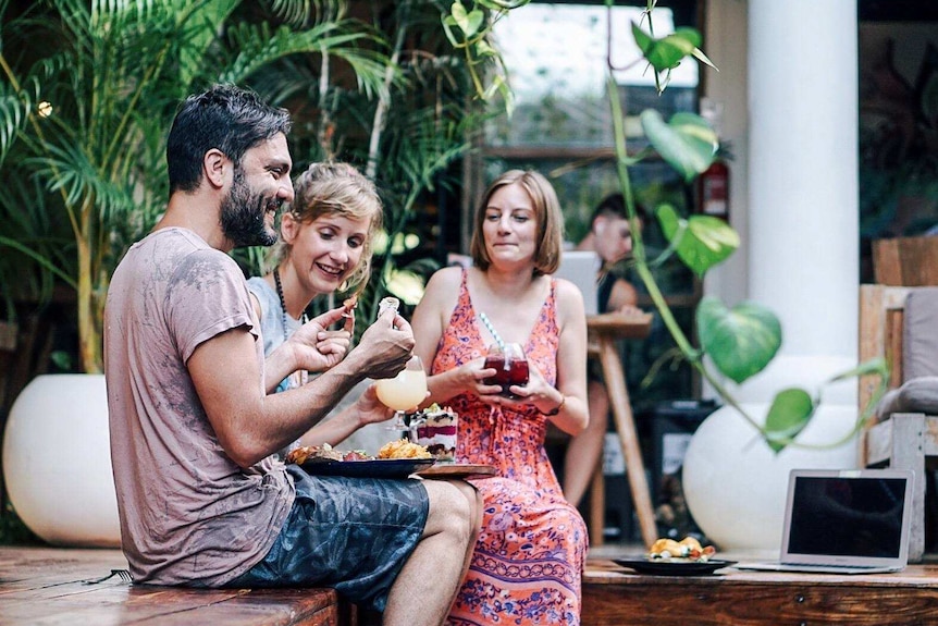 a man laughs with two women